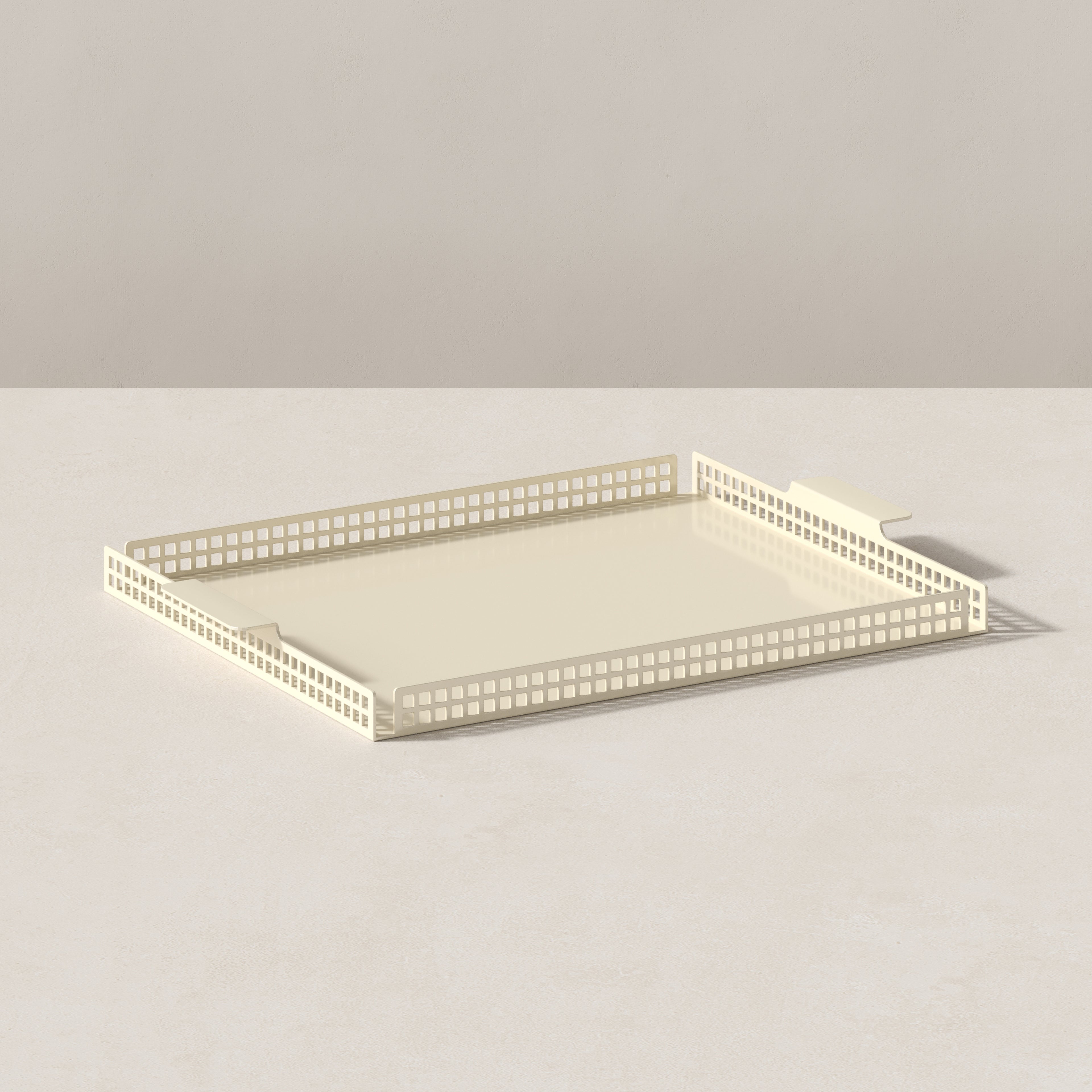 Art Deco serving tray in butter cream finish, angled view showing perforated steel sides