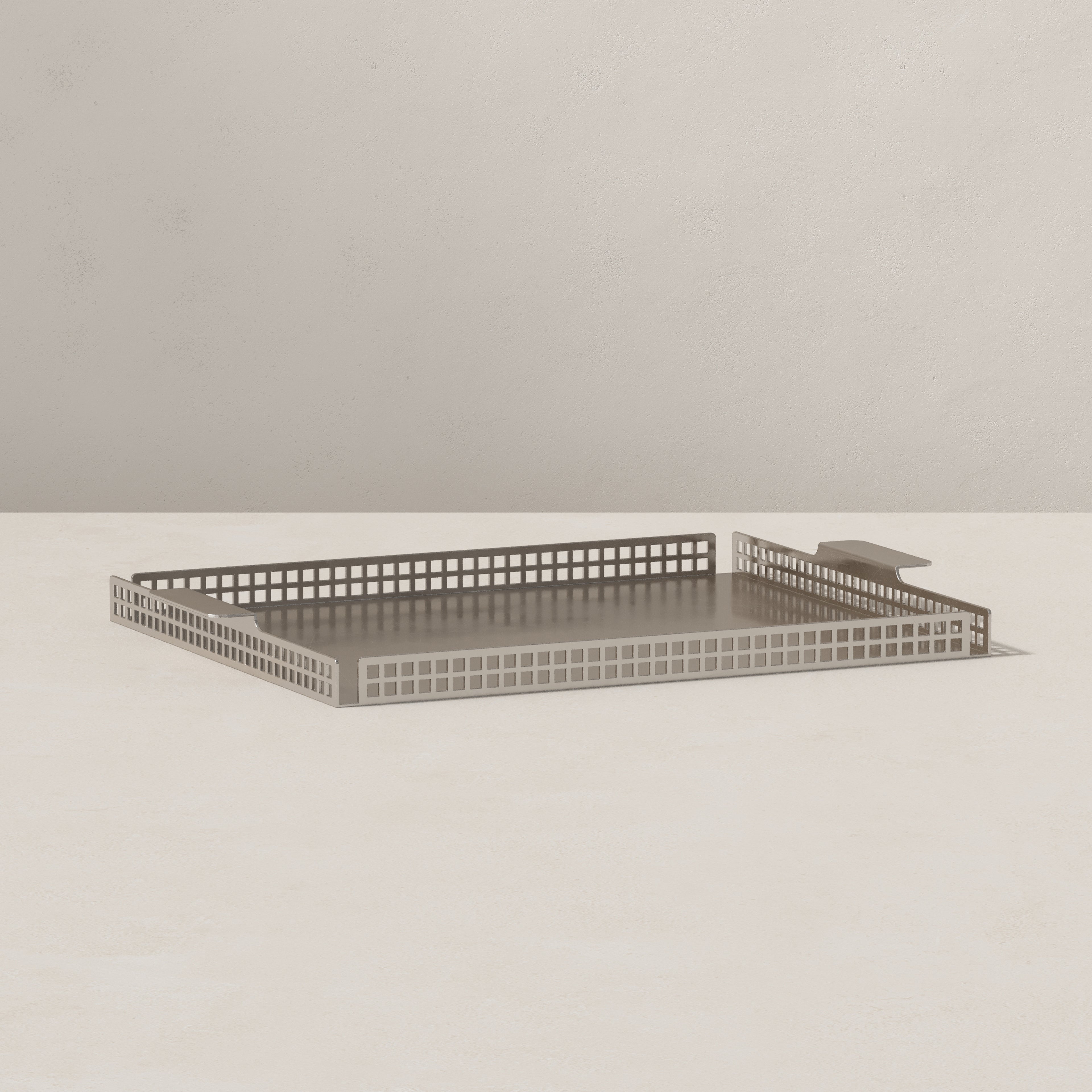 Art Deco serving tray in nickel finish, angled view showing perforated steel sides and flat base on neutral background