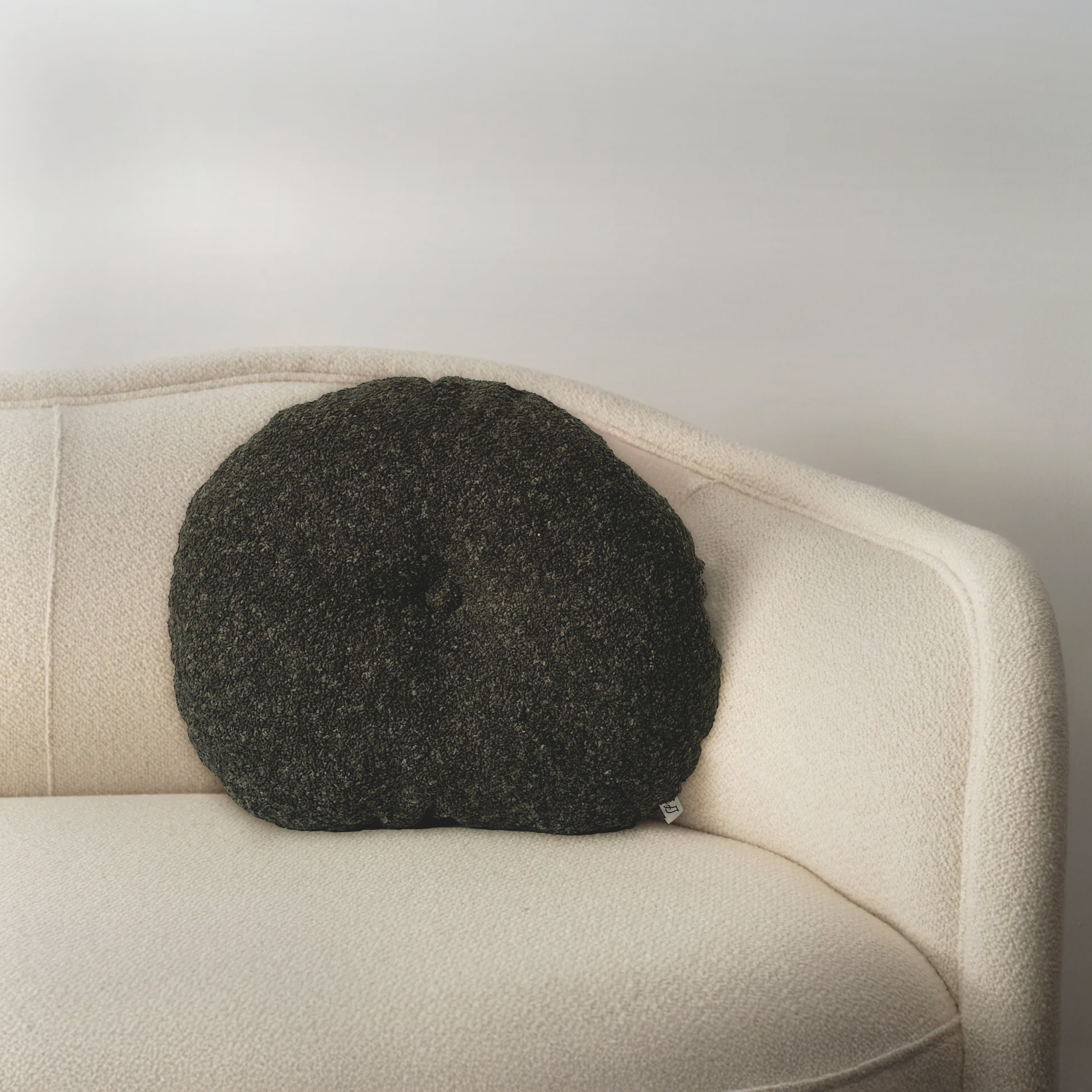Cloud Cushion in moss bouclé styled on a neutral sofa