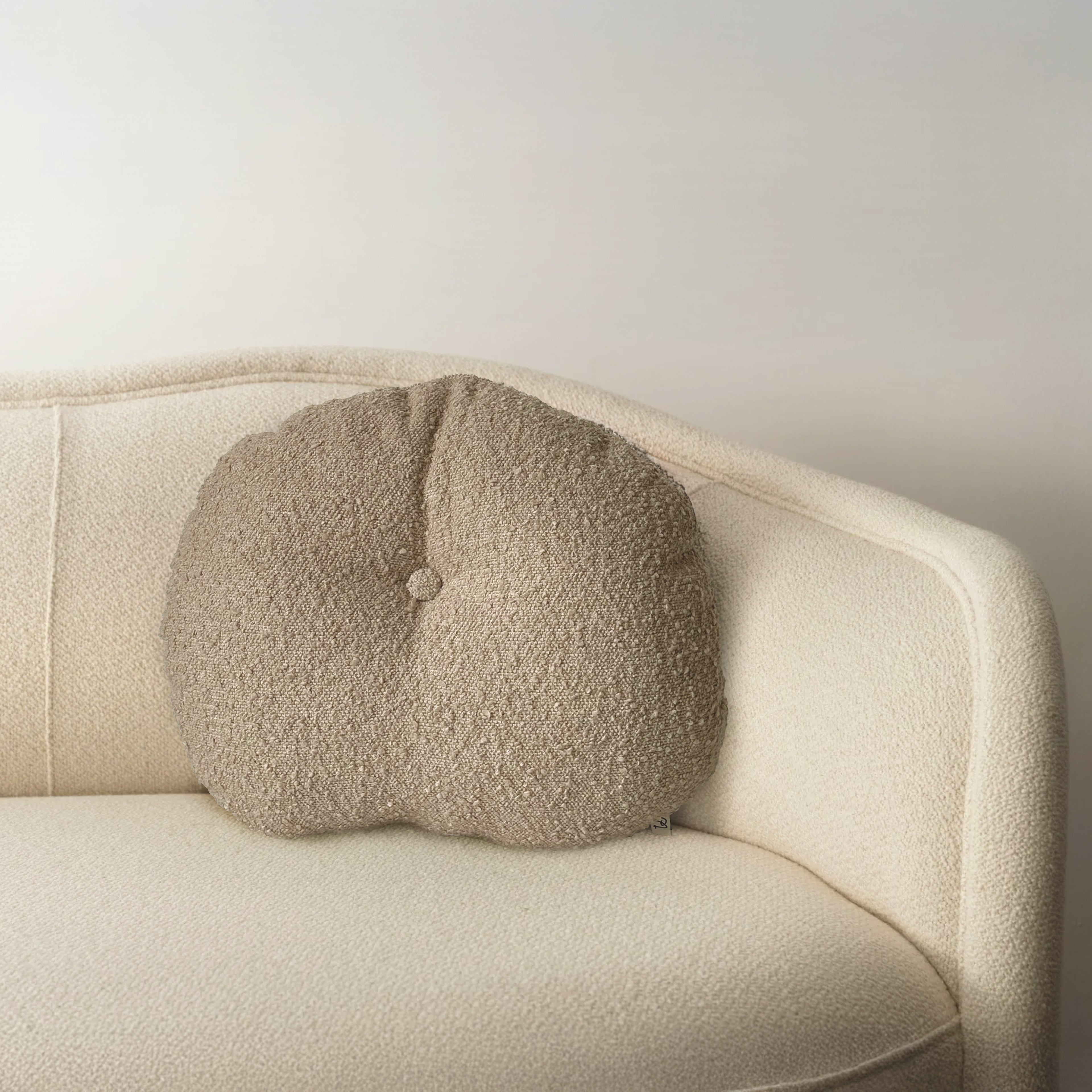 Cloud Cushion in oatmeal bouclé styled on a neutral sofa
